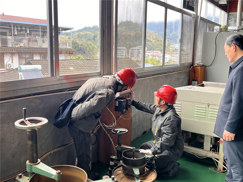 “电骡子”谌官龙、吴剑帮助茶农检查制茶设备。单位供图