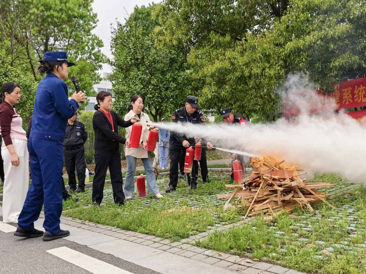 消防宣传员指导参训人员正确使用灭火器材开展灭火实操（单位供图）