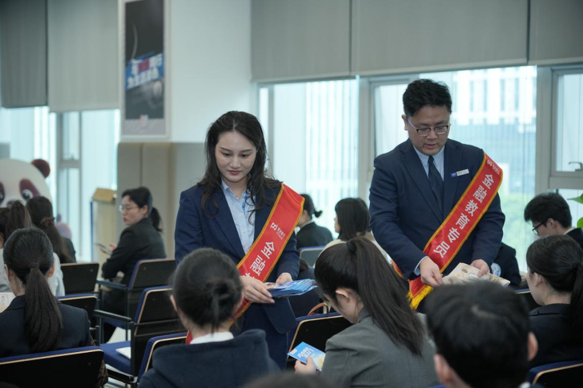 宣講專員為學子們發放金融知識手冊。單位供圖