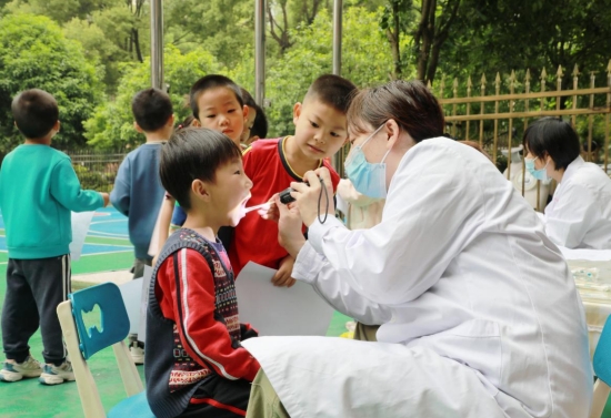 医护人员为孩子们检查口腔健康情况。周林凤摄
