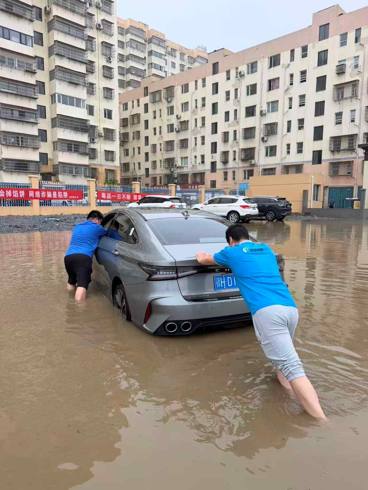 理赔员与车主将车推离积水。单位供图