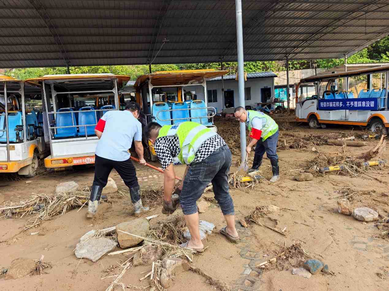现场理赔人员与施工队清理泥沙碎石。单位供图