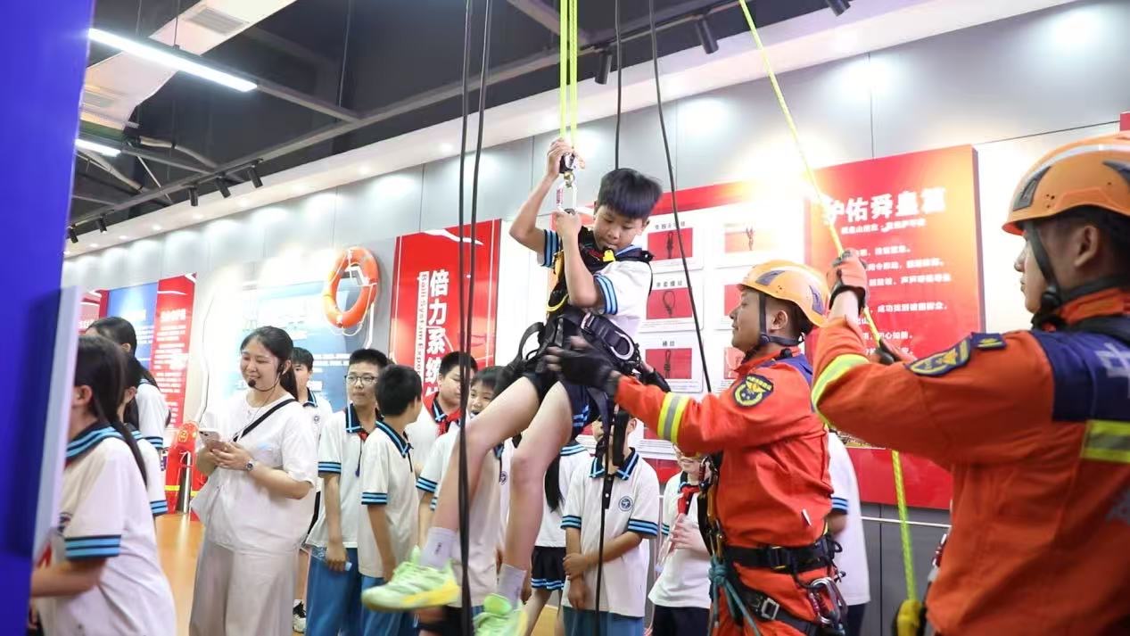 消防战士在指导学生体验救援器材。邓志宇摄