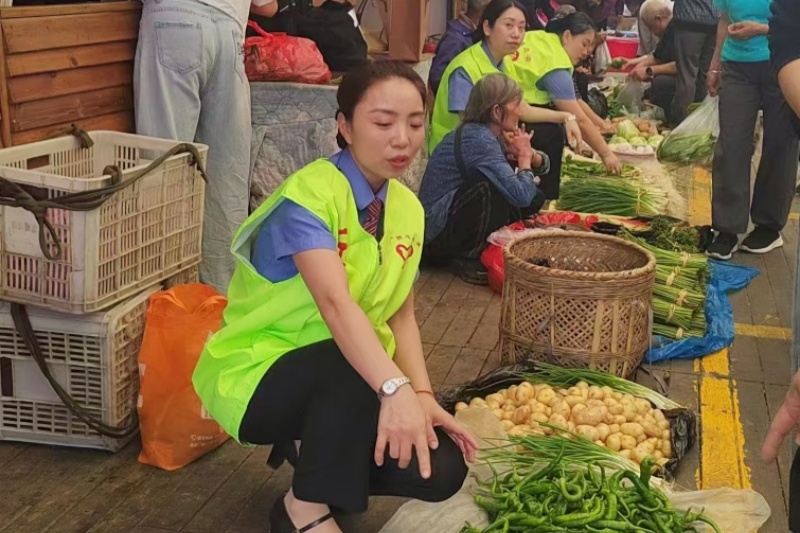 在线下集市，队员们化身志愿者帮农户售卖蔬果。伍洲摄