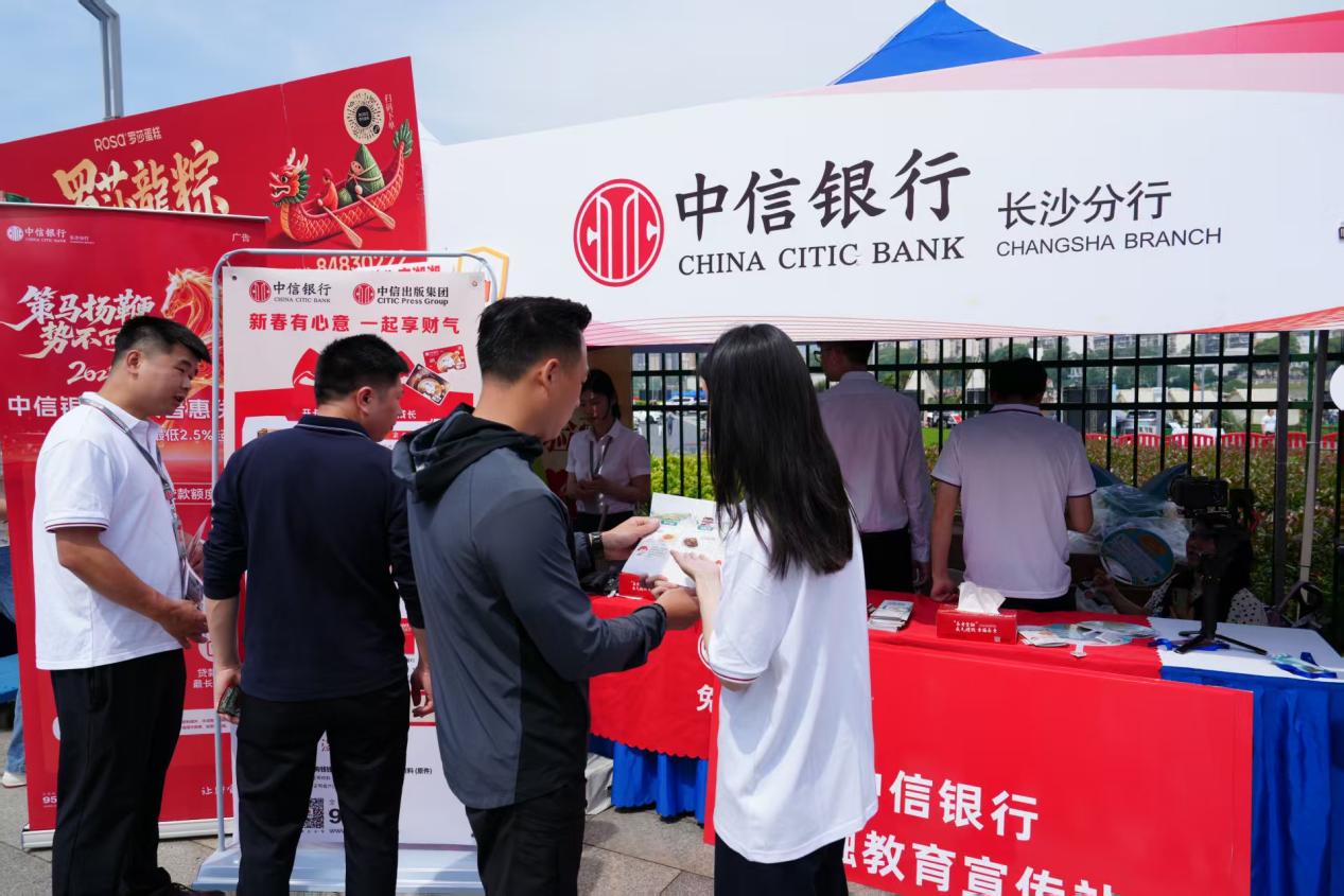 工作人员在龙舟赛场外科普金融知识。单位供图