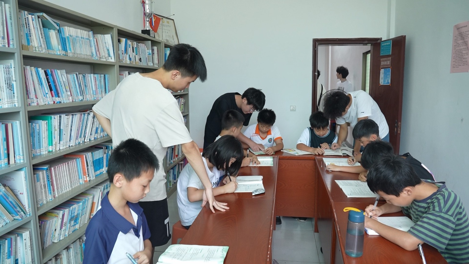 杜家村综合楼内，大学生志愿者正在辅导作业。受访单位供图