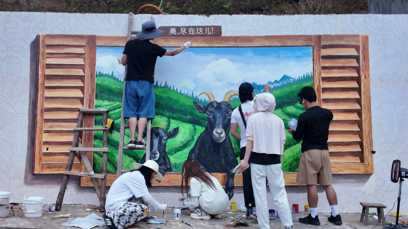 实践团大学生志愿者在折尔村绘制主题墙绘（单位供图）