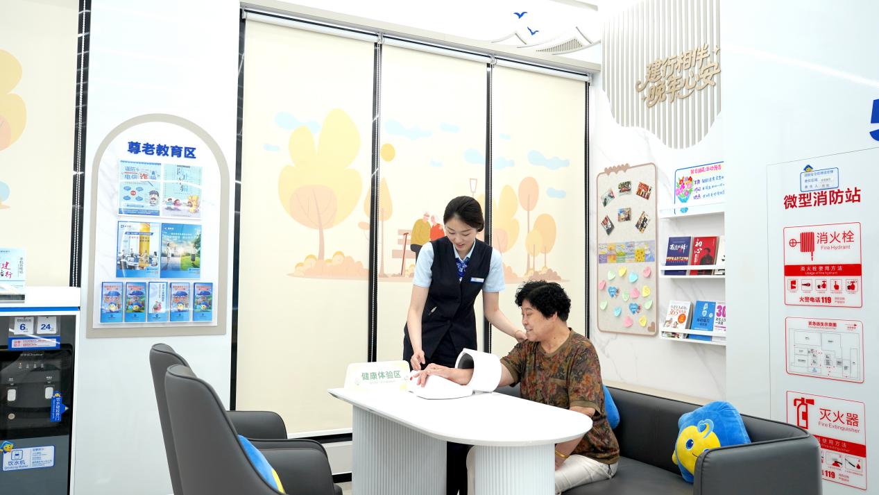 工作人员为老年客户测量血压。单位供图