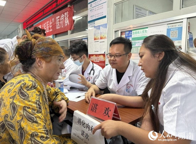 托克逊县卫生院，援疆医生（右二）为老人提供健康建议，当地医疗工作者（右一）在一旁翻译。人民网记者 刘汕摄