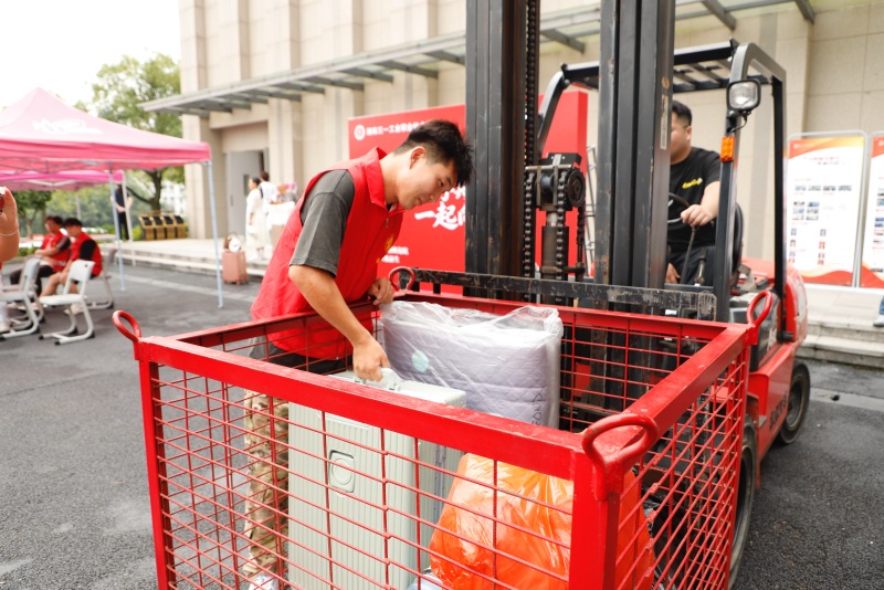 学校志愿者将新生行李搬上叉车。受访单位供图