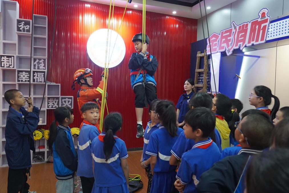 學生在消防員指導下體驗繩索救援項目。文子晴攝