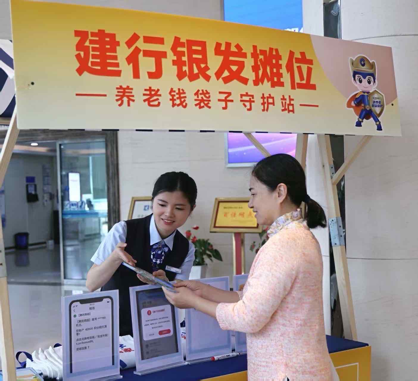 银发摊位前，工作人员正在向居民普及养老金融安全知识。