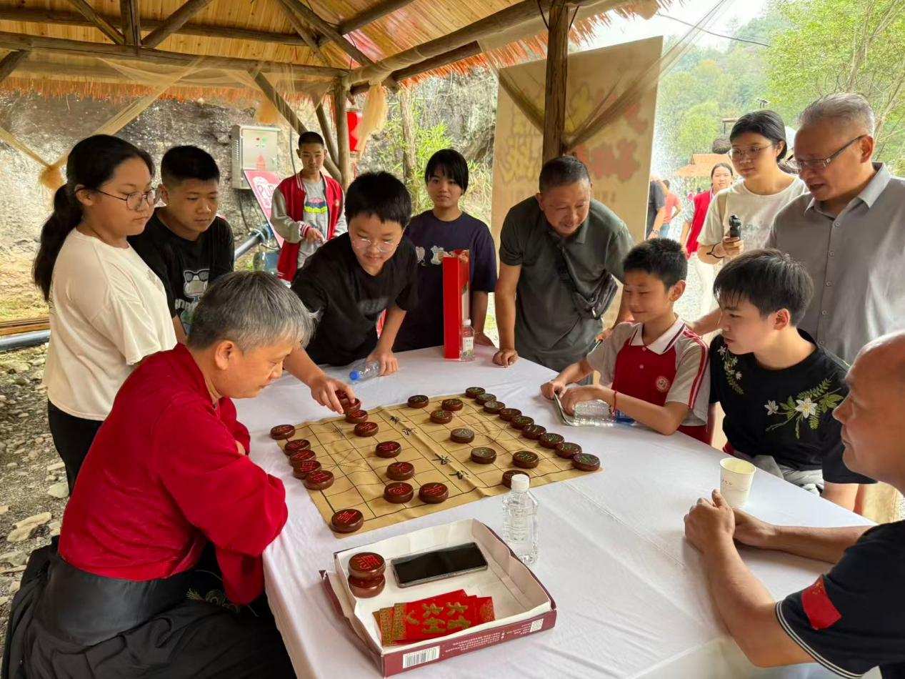 “鄉村棋王”NPC接受小學生挑戰，引發游客駐足圍觀。單位供圖