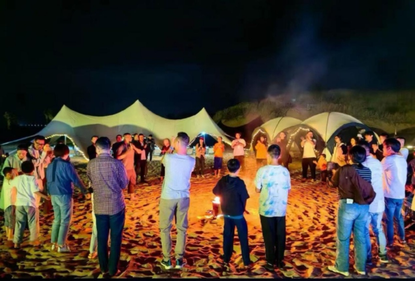 青山島沙灘營地氛圍感拉滿，游客圍坐篝火旁，吹風、聽曲、享夜色。單位供圖