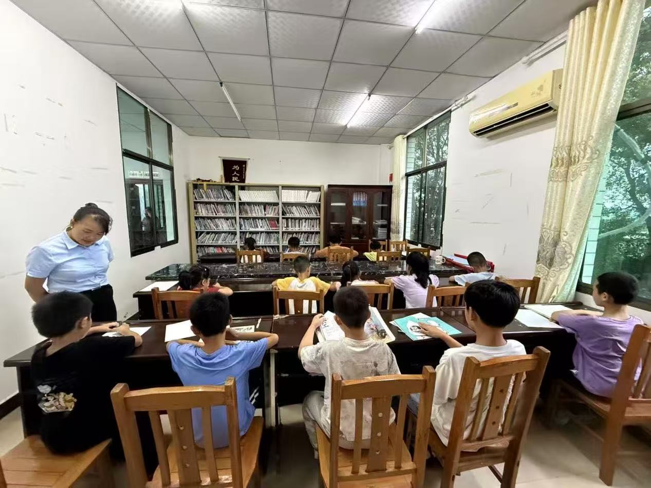 白牙市鎮宥江橋村公益托管班，志願者正在輔導孩子們寫作業。陳俊宏攝