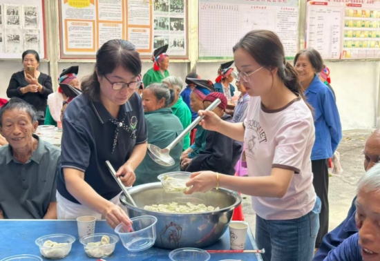 门楼下瑶族乡舍子源村干部和志愿者在给老人盛饺子。盘天英摄