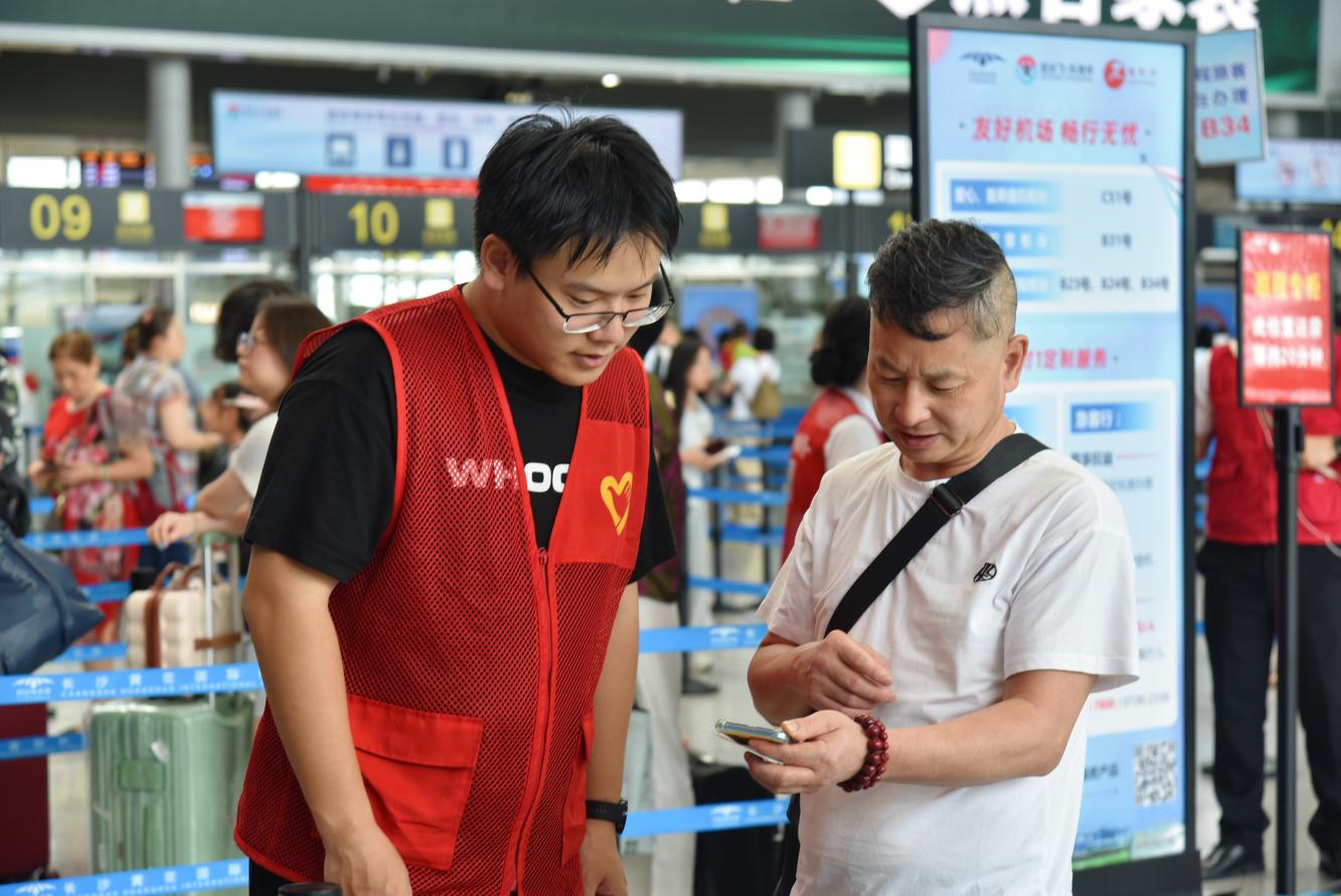 長沙機場高校青年志願者為旅客提供咨詢服務。湖南機場集團供圖