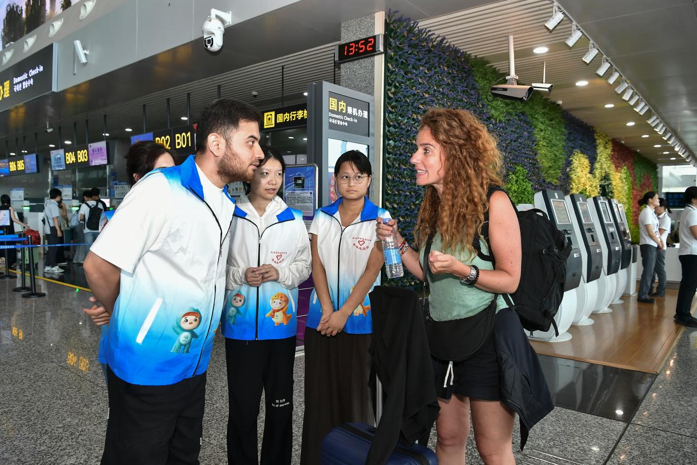 張家界機場“譯文旅”外籍青年志願者為國際旅客解答航班改簽流程。湖南機場集團供圖