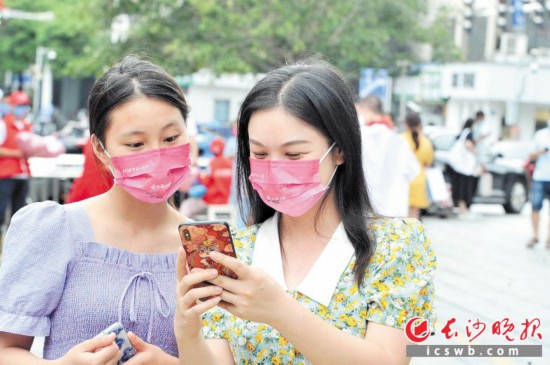 過路的市民佩戴上“七夕主題口罩”后拍照發朋友圈。長沙晚報全媒體記者 賀文兵 攝