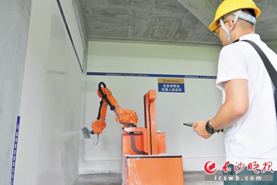   6月15日，望城区国欣·云境府项目工地上，工人操作室内喷涂机器人进行作业。王志伟 摄